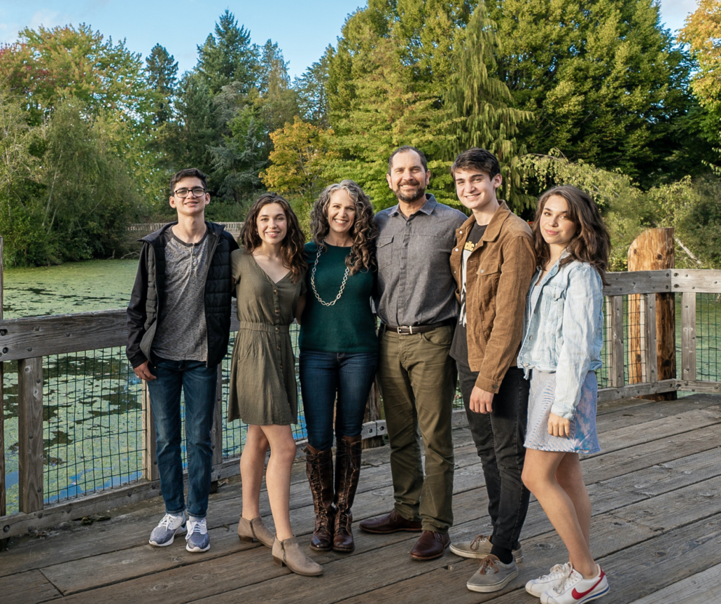 A group of people standing on top of a wooden dock.