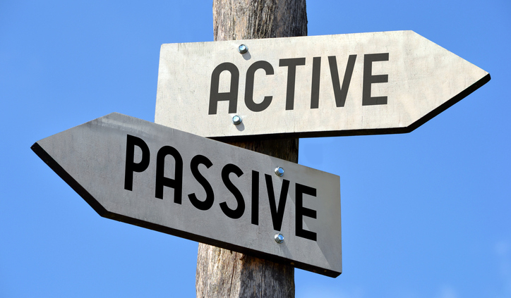 Wooden signpost with two arrows and black words on them.